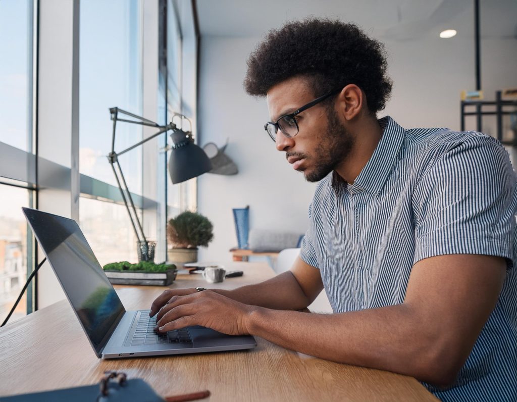 homem escrevendo copy no notebook em sala de escritório moderna e clara copywriting f5 ads